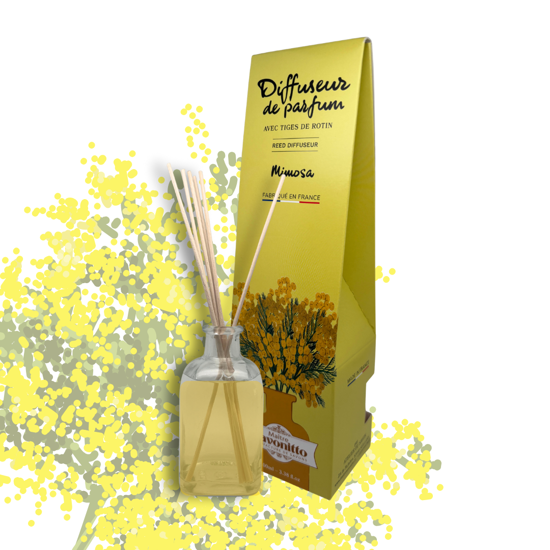 Diffuseur de parfum au mimosa, fragrance poudrée et printanière présentée dans son flacon en verre avec ses tiges de rotin