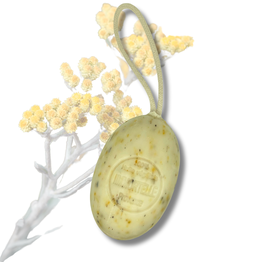 Savon artisanal sur corde à la fleur d’immortelle, soin exfoliant et ensoleillé présenté dans sa forme ovale authentique.